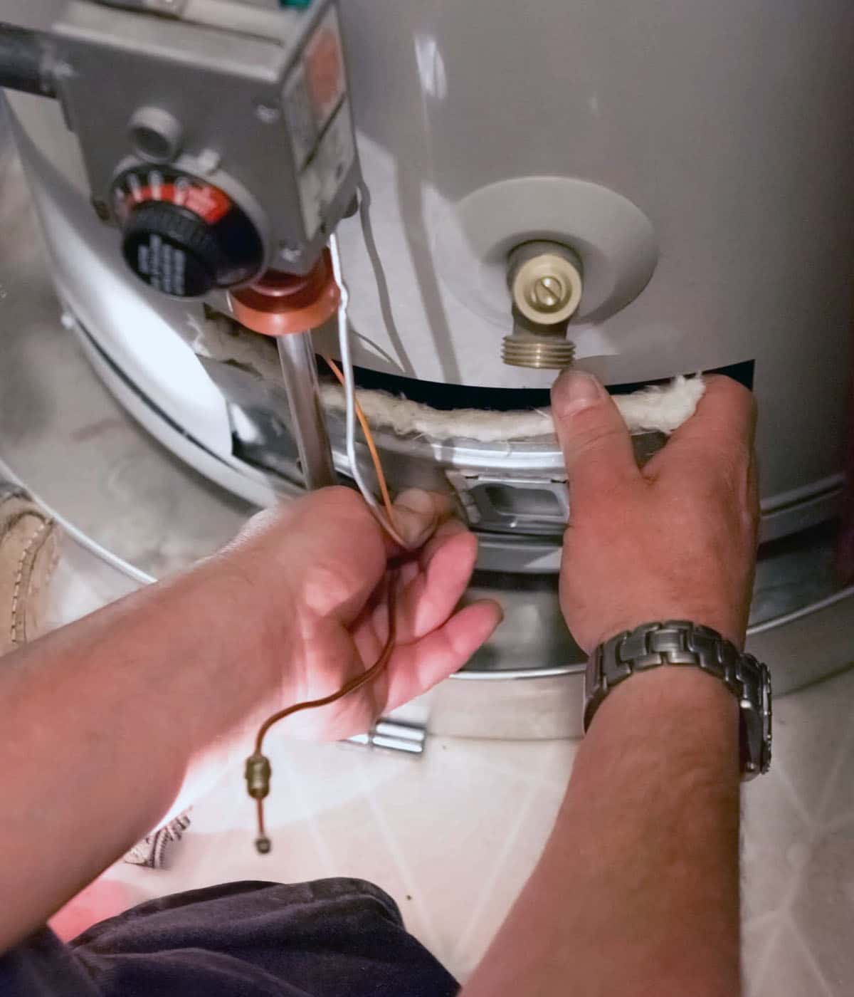 Close-up of hands working on a water heater